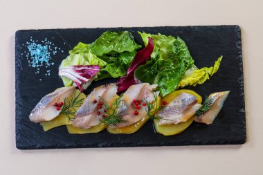 Patates ve soğanlı ringa balığı.