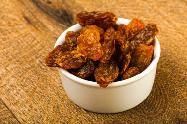 Ahşap arka plan üzerinde kase kuru kuru üzüm