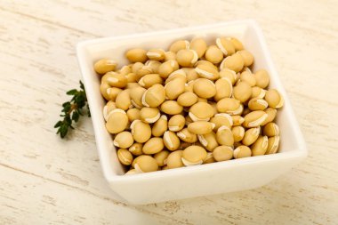 Kase ahşap arka plan üzerinde çiğ beyaz fasulye