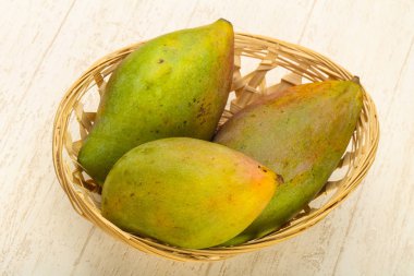 Tropikal meyve - mango yığın ahşap arka plan üzerinde