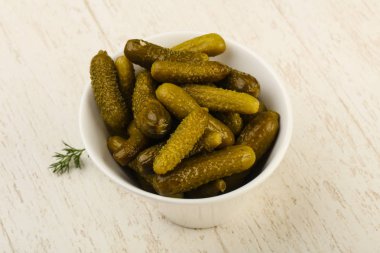 Ahşap arka plan üzerinde kaseye Picled salatalık