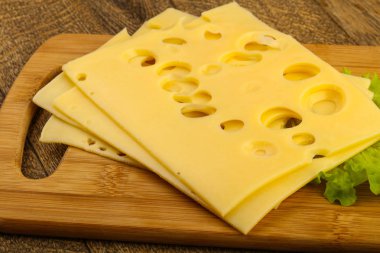 Ahşap arka plan üzerinde dilimlenmiş peynir salata yaprakları