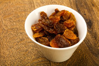 Ahşap arka plan üzerinde kase kuru kuru üzüm