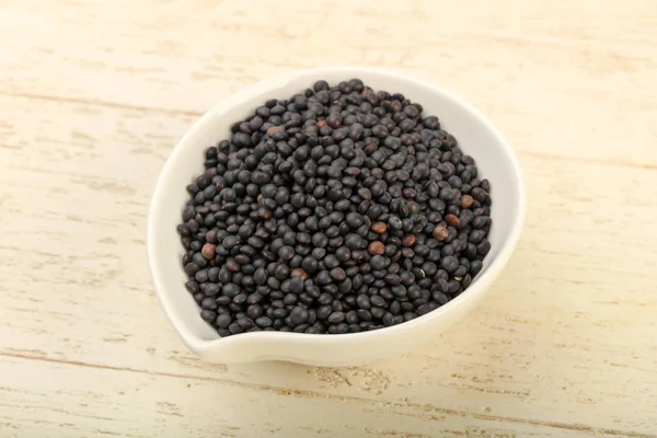 Kase üzerinde ahşap yemek pişirmek için hazır siyah mercimek