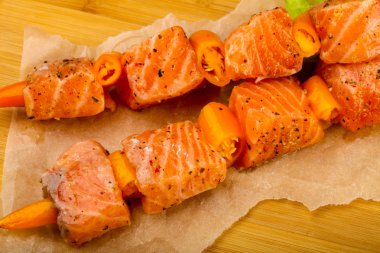 Pişmeye hazır baharatlı çiğ somon şişi.