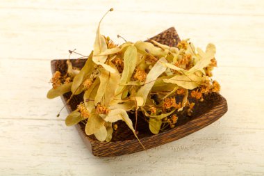 Kase ahşap arka plan üzerinde kurutulmuş linden yığın