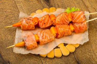 Pişmeye hazır baharatlı çiğ somon şişi.