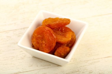 Kuru Kayısı yığın içinde kase ahşap arka plan üzerinde