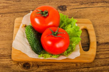 Salatalık ve domates salatası ile ahşap arka plan üzerinde bırakır