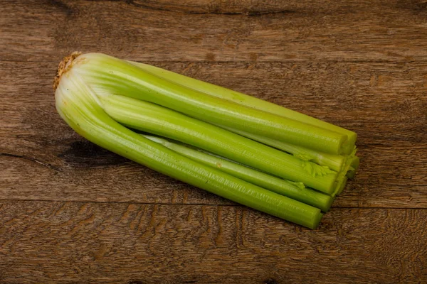 Organic food - celery sticks over wooden background