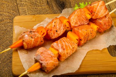 Pişmeye hazır baharatlı çiğ somon şişi.