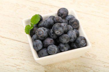 Kase ahşap arka plan üzerinde yabanmersini