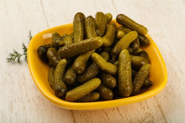 Ahşap arka plan üzerinde kaseye Picled salatalık