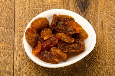 Ahşap arka plan üzerinde kase kuru kuru üzüm