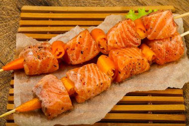 Pişmeye hazır baharatlı çiğ somon şişi.