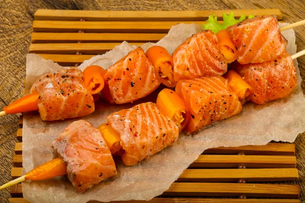 Pişmeye hazır baharatlı çiğ somon şişi.