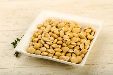 Kase ahşap arka plan üzerinde çiğ beyaz fasulye