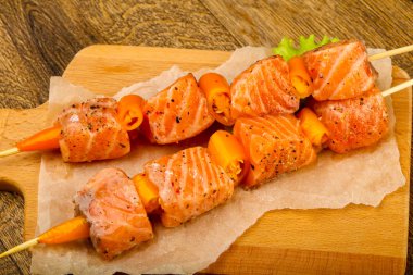 Pişmeye hazır baharatlı çiğ somon şişi.