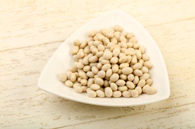 Kase ahşap arka plan üzerinde beyaz kuru fasulye