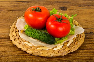 Salatalık ve domates salatası ile ahşap arka plan üzerinde bırakır