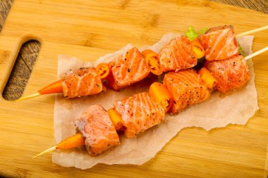 Pişmeye hazır baharatlı çiğ somon şişi.