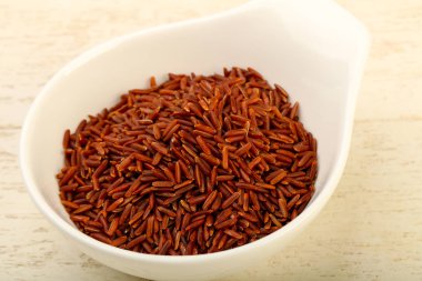 Kase ahşap arka plan üzerinde ham kahverengi pirinç