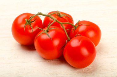 Ahşap arka plan üzerinde olgunlaşmış domates şube