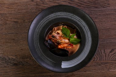 Fesleğen yaprakları ile deniz ürünleri makarna