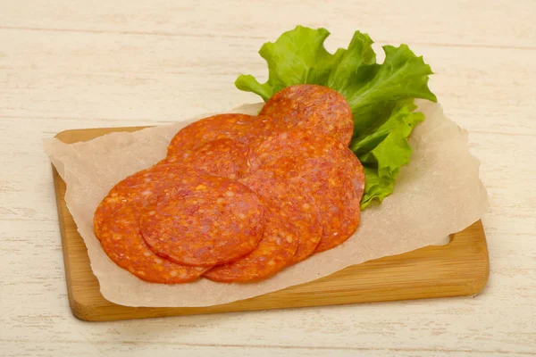 Peperoni Wurst Scheiben Geschnitten Über Hölzernen Hintergrund — Stockfoto