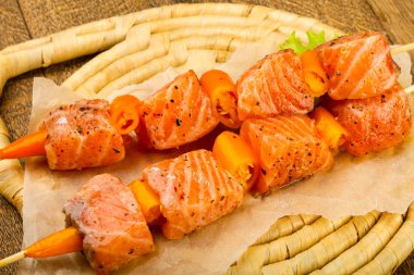 Pişmeye hazır baharatlı çiğ somon şişi.