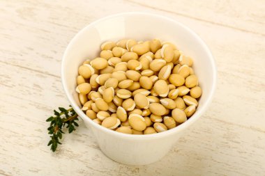 Kase ahşap arka plan üzerinde çiğ beyaz fasulye