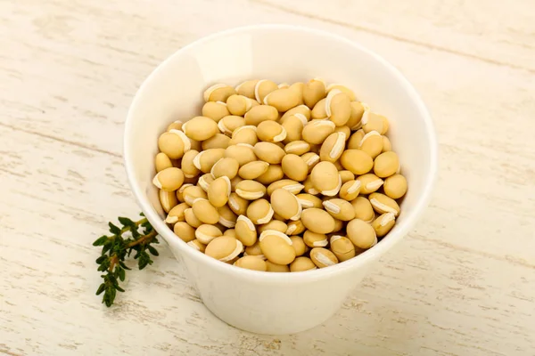 Kase ahşap arka plan üzerinde çiğ beyaz fasulye