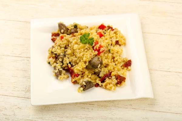 Bulgur with chicken hearts and dry tomatoes