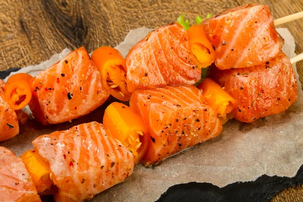 Pişmeye hazır baharatlı çiğ somon şişi.