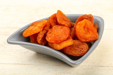 Kuru Kayısı yığın içinde kase ahşap arka plan üzerinde