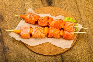 Pişmeye hazır baharatlı çiğ somon şişi.