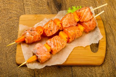 Pişmeye hazır baharatlı çiğ somon şişi.