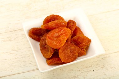 Kuru Kayısı yığın içinde kase ahşap arka plan üzerinde