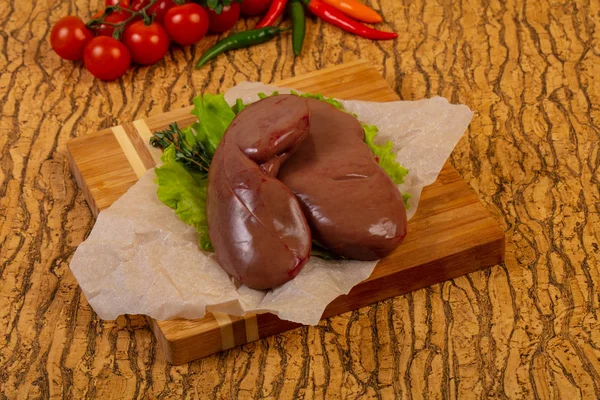 Raw pork kidneys ower wooden background — Stock Image Raw Pork Kidneys Ower Wooden Background Stock Picture