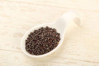 Kase ahşap arka plan üzerinde siyah hardal tohumu yığın