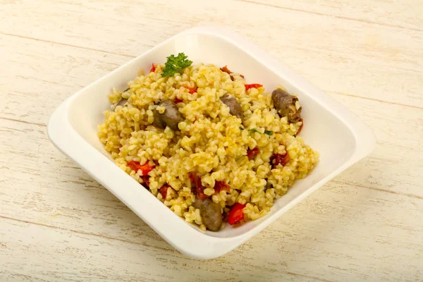 Bulgur with chicken hearts and dry tomatoes