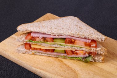 Jambon, peynir, salata yaprakları, domates ve salatalık turşusu ile kulüp sandviç