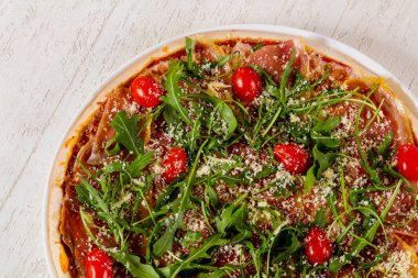 Hamon ve roka ile pizza.