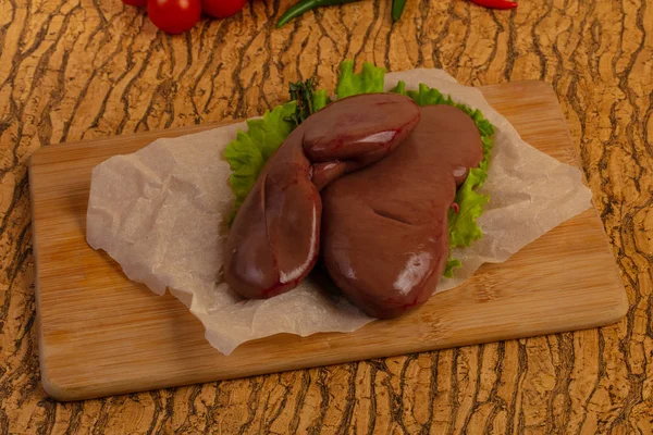 Raw pork kidneys ower wooden background — Stock Image Raw Pork Kidneys Ower Wooden Background Stock Photo