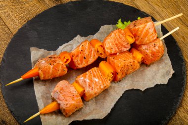 Pişmeye hazır baharatlı çiğ somon şişi.