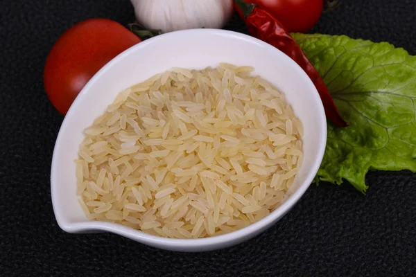 碗里未煮熟的未煮熟的米饭供应胡椒和沙拉叶 — 图库照片