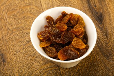 Ahşap arka plan üzerinde kase kuru kuru üzüm