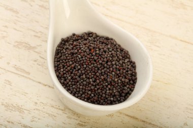 Kase ahşap arka plan üzerinde siyah hardal tohumu yığın