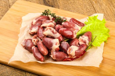 Çiğ tavuk kalbi kekik dalıyla istiflenmiş.