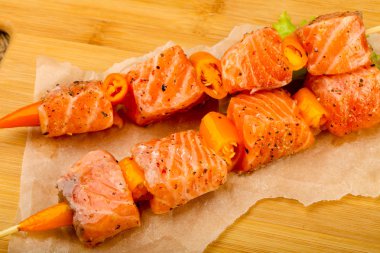 Pişmeye hazır baharatlı çiğ somon şişi.